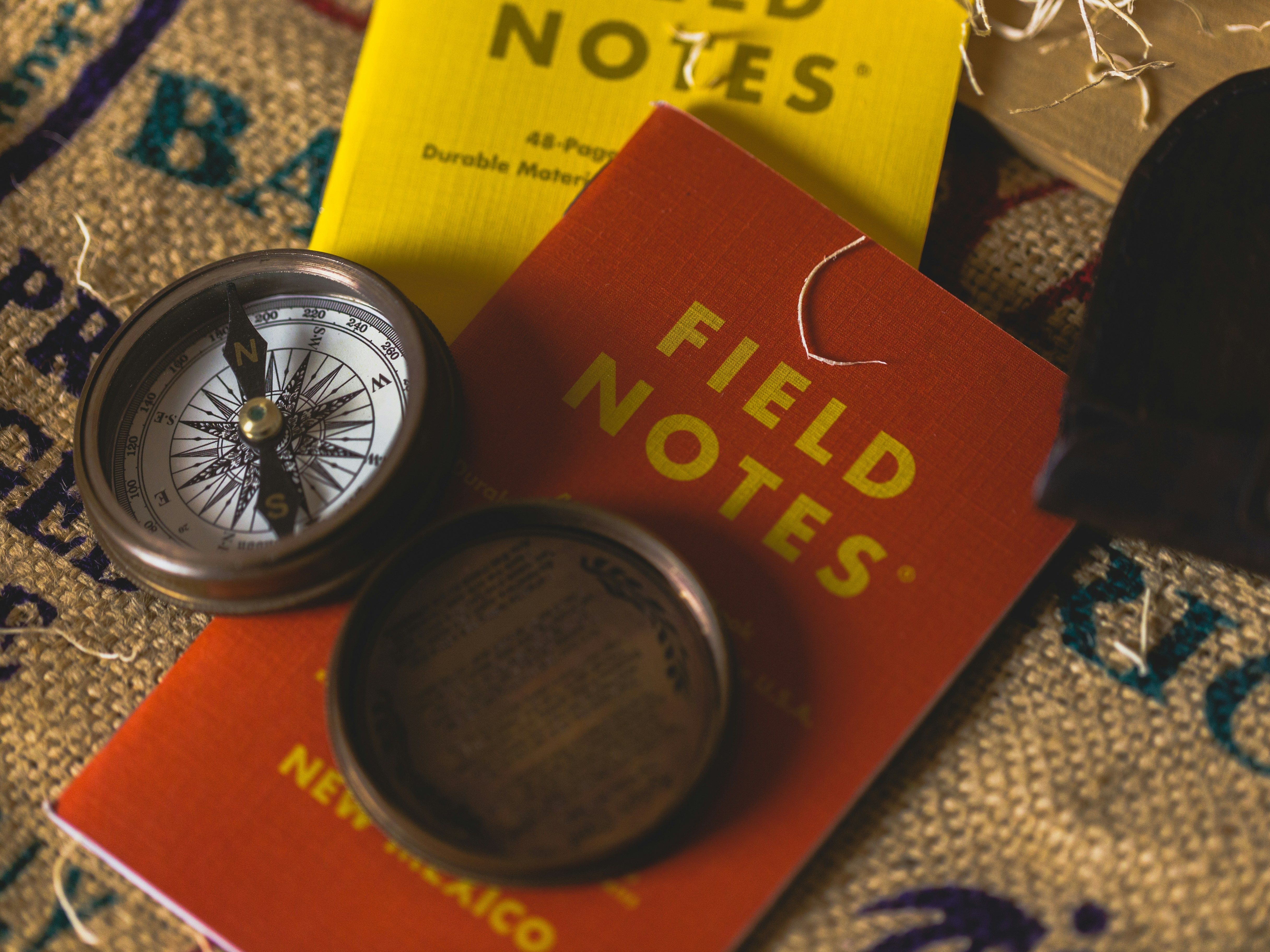Picture of a compass and a notebook titled "Field Notes"
