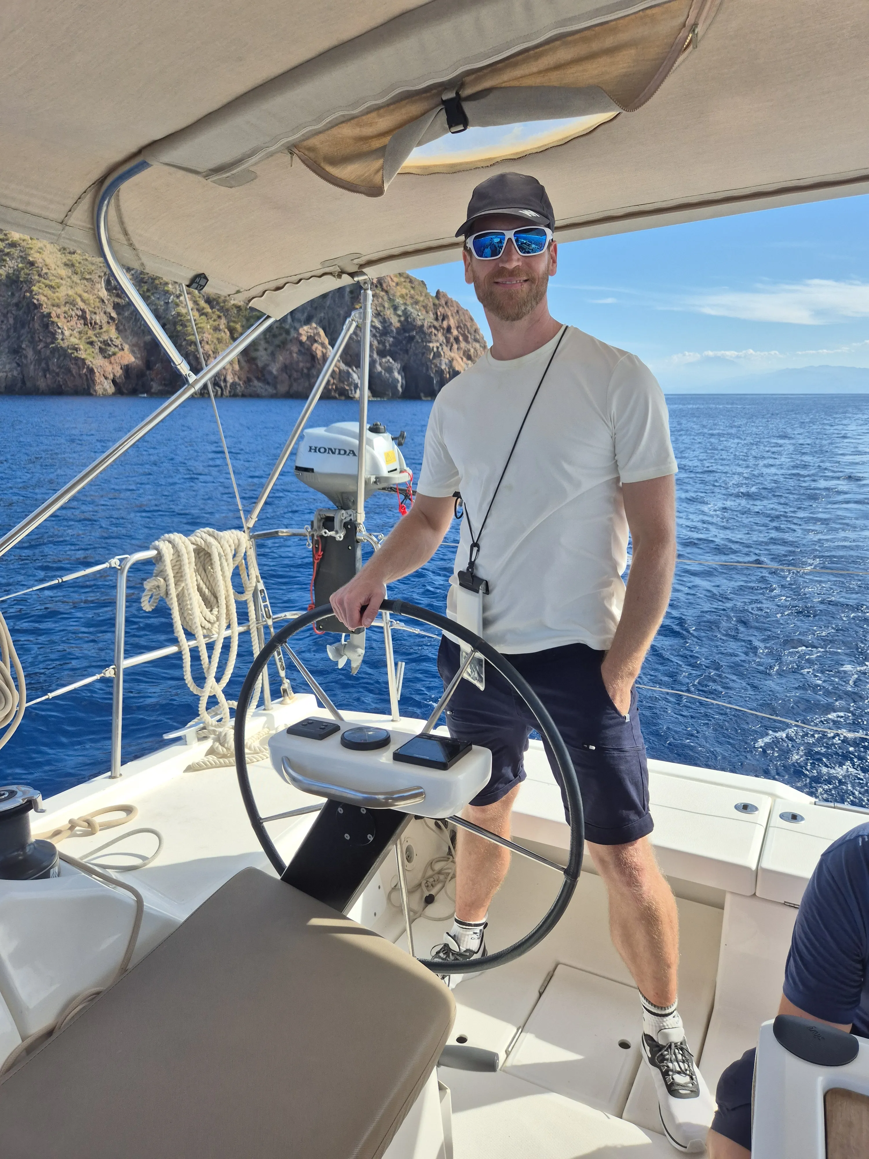 Image of myself at the helm of a sailing yacht in Sicily, Italy.